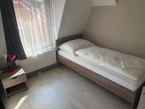 a small bed in a room with a window at Lenti Central Apartman in Lenti
