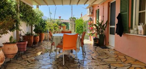 a table and chairs on a patio with potted plants at Margarita's house in Sami