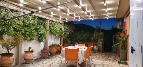 a patio with a table and chairs and potted plants at Margarita's house in Sami