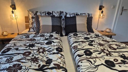 a bedroom with a bed with a black and white comforter at Auszeitplatzl in Unken