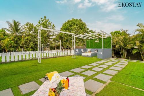 a garden with a gazebo and a picnic table at EKOSTAY - Mount Emerald Villa in Alibaug