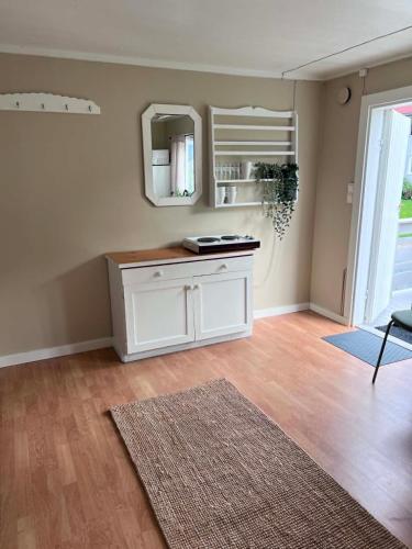a room with a white cabinet and a mirror at Hovstø Hytter & Rom in Seljord