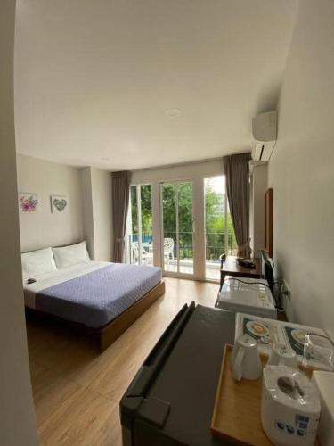 a bedroom with a bed and a table in a room at TEAK VILLA in Bangna