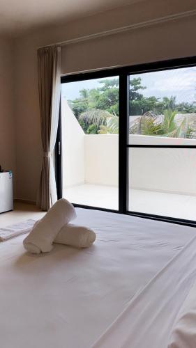 a white bed with a towel on it in a bedroom at Kano Boutique Hotel Paje in Paje