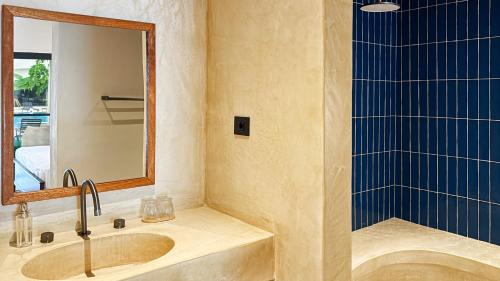 a bathroom with a sink and a shower at Kano Boutique Hotel Paje in Paje