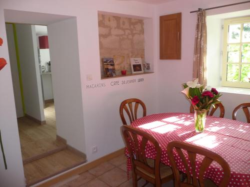 a dining room with a table and chairs and a mirror at Gite 4* L'Orée des Fleurs in Grézillé