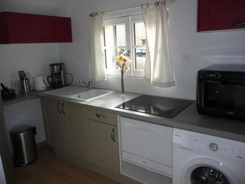 a kitchen with a sink and a microwave at Gite 4* L'Orée des Fleurs in Grézillé