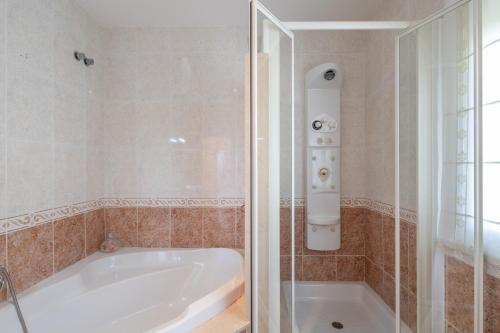 a bathroom with a bath tub and a shower at Villa las Terrenas in Calafell
