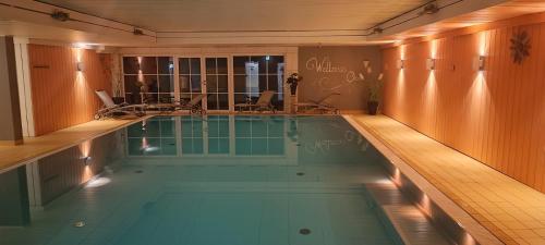 a large swimming pool with chairs in a building at Schloss Kirchham Appartement - & Wellnessanlage in Kirchham