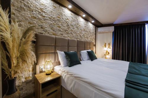 a bedroom with a large bed and a brick wall at Sote Mountain View in Samokov
