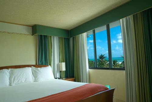 a hotel room with a bed and a large window at The Fritz Hotel in Miami Beach