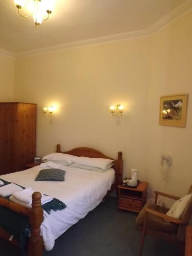 a bedroom with a large bed and a telephone at Palace Hotel - Small Hotel in Oban