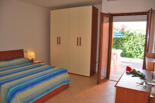 カンポ・ネッレルバにあるAppartamenti Margheritaのベッドルーム1室(ベッド1台付)、スライド式ガラスドアが備わります。