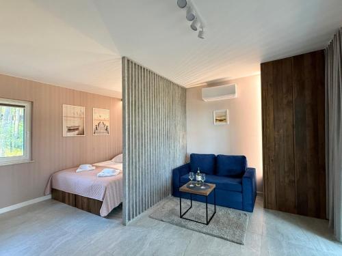 a bedroom with a bed and a blue couch and a table at Turawa Lake Residence in Turawa