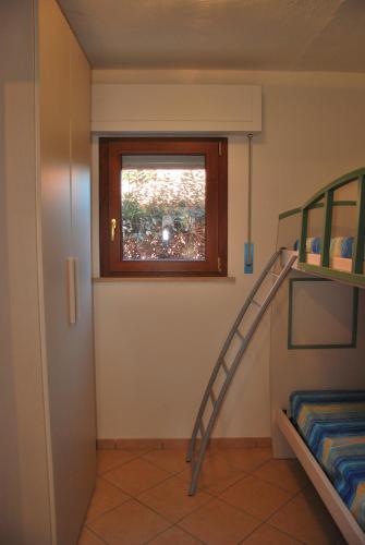 a room with bunk beds and a ladder in it at Appartamenti Margherita - Zona mare con clima e posti auto in Campo nell'Elba