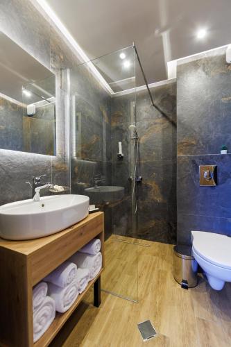 a bathroom with a sink and a shower and a toilet at Sote Mountain View in Samokov