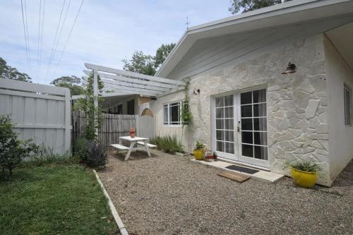 a stone house with a picnic table in front of it at Wisteria Hideaway in Coffs Harbour