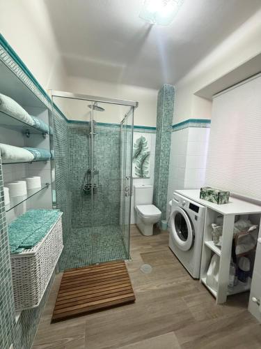 a bathroom with a shower and a washing machine at Casa las Hiedras in Marín
