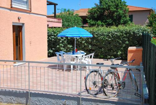a bike parked next to a table with an umbrella at Appartamenti Margherita - Zona mare con clima e posti auto in Campo nell'Elba