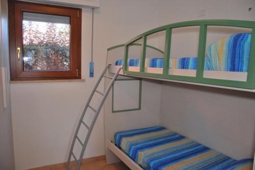 a bunk bed with a ladder next to a window at Appartamenti Margherita - Zona mare con clima e posti auto in Campo nell'Elba
