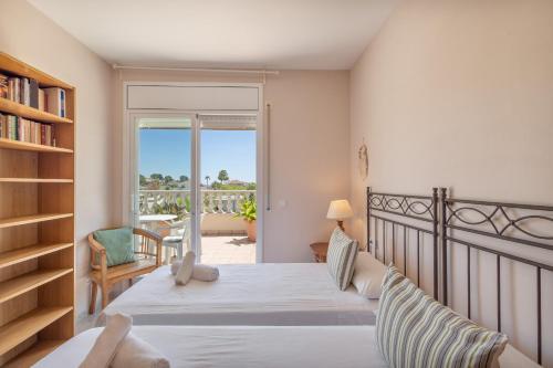 a bedroom with a bed and a balcony at Villa las Terrenas in Calafell