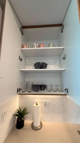a kitchen with a shelf with dishes and a plant at Wallace Luxurious in Los Angeles