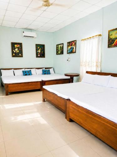 two beds in a room with two beds sidx sidx sidx at Cali Homestay Tây Ninh in Tây Ninh