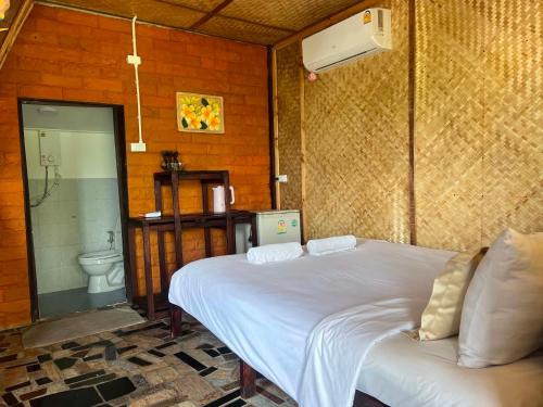 a bedroom with a white bed and a toilet at Benny monkey house in Rayong