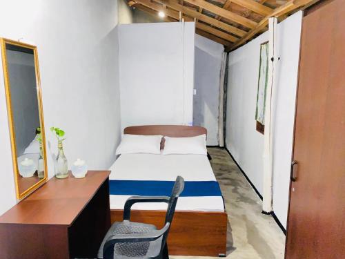 a room with a bed and a desk and a chair at Sea secret in Arugam Bay
