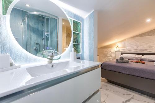 a bathroom with a sink and a mirror and a bed at Prestige House in Nulvi