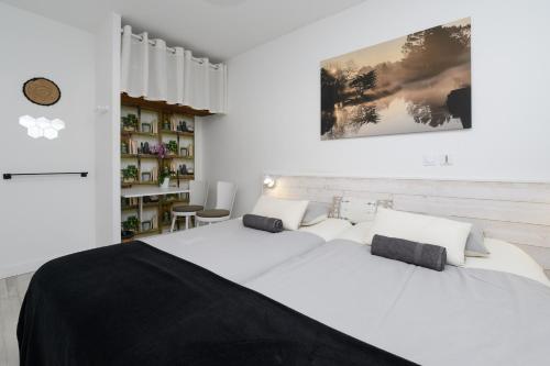 a white bedroom with a large white bed with pillows at Chambre d'hôtes Spiren in Baden