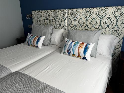 a white bed with two pillows on top of it at HOSTAL TREVELEZ in El Ejido