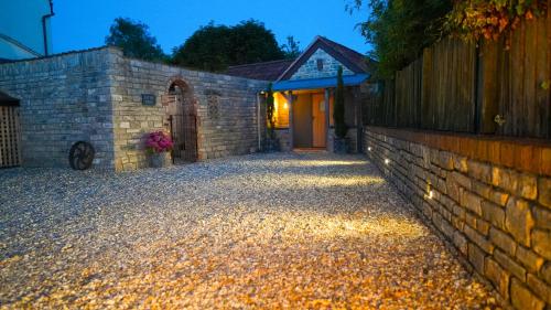 a stone driveway with a brick wall and a door at Tin Bath As Glorious as its Namesake in Aller