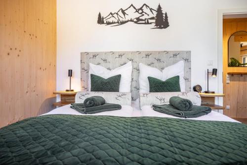 a bedroom with a large bed with green sheets and pillows at Ferienhaus Auerberg Sweet in Stötten am Auerberg