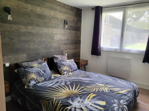 a bedroom with a bed with blue comforter and pillows at Le Chêne Pommier Proche Honfleur in Fatouville-Grestain