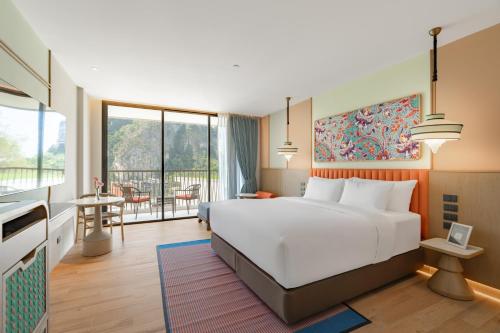 a hotel room with a bed and a balcony at Grand Mercure Krabi Ao Nang in Ao Nang Beach