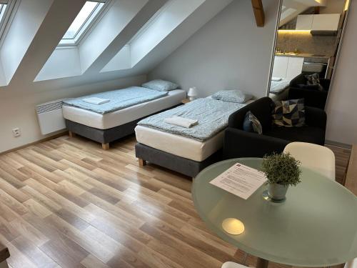 a living room with two beds and a table at Apartmány Skryjova in Brno