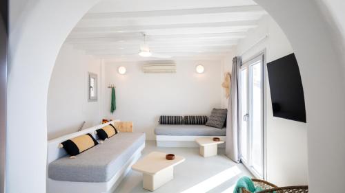 a white living room with a couch and a table at Cavo Blue Villas in Elia Beach
