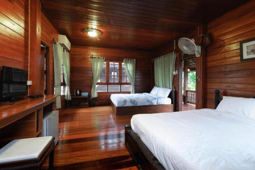 a bedroom with two beds and a flat screen tv at Huan Aumpron Resort in Ban Kha Ngam