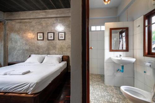 a bedroom with a bed and a bathroom with a sink at Huan Aumpron Resort in Ban Kha Ngam