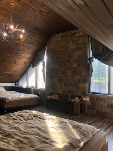 a bedroom with two beds and a brick wall at Guest House ELIYA in Devin