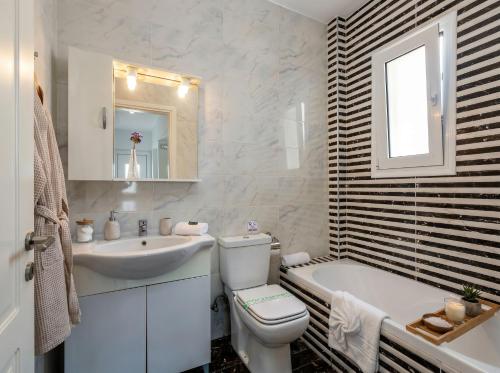 a white bathroom with a sink and a toilet and a tub at Lilu Villa 2 with Private Pool and Seaview in Tigaki