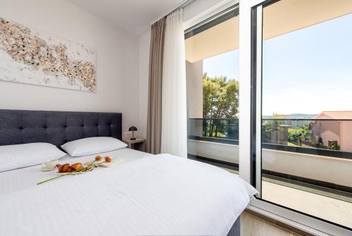 a bedroom with a white bed and a large window at Villa Nika with pool & parking near Zadar in Bibinje