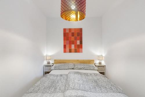 a bedroom with a bed and a chandelier at Premium Ferienwohnung Dörr in Singen