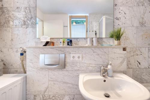a white bathroom with a sink and a mirror at Premium Ferienwohnung Dörr in Singen