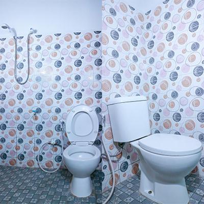 a bathroom with a toilet and a shower curtain at Artemis Hotel Bekasi in Cikunir Satu