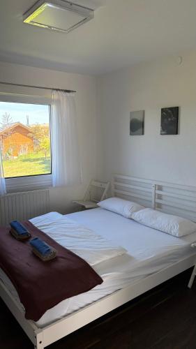 a white bed in a bedroom with a window at Haus am Waldrand in Göttschach