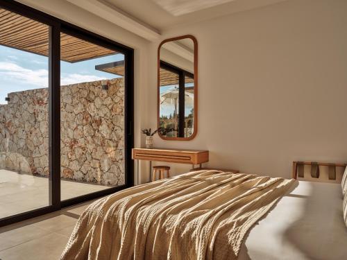 a bedroom with a bed and a mirror at Theros Luxury Suites in Agios Nikolaos