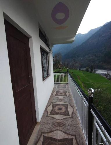 a balcony with a door and a view of a mountain at Tapovan ganga view in Uttarkāshi