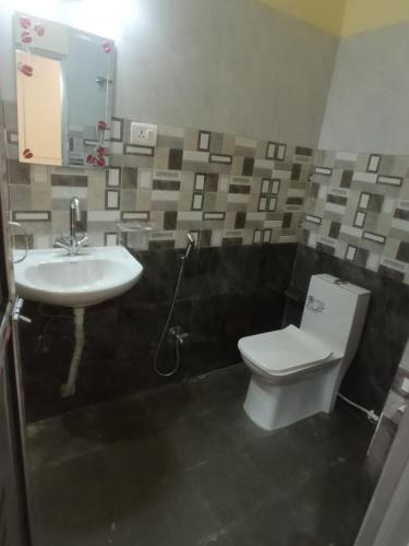 a bathroom with a white toilet and a sink at Bindwasini Hotel And Party Palace in Bīrganj